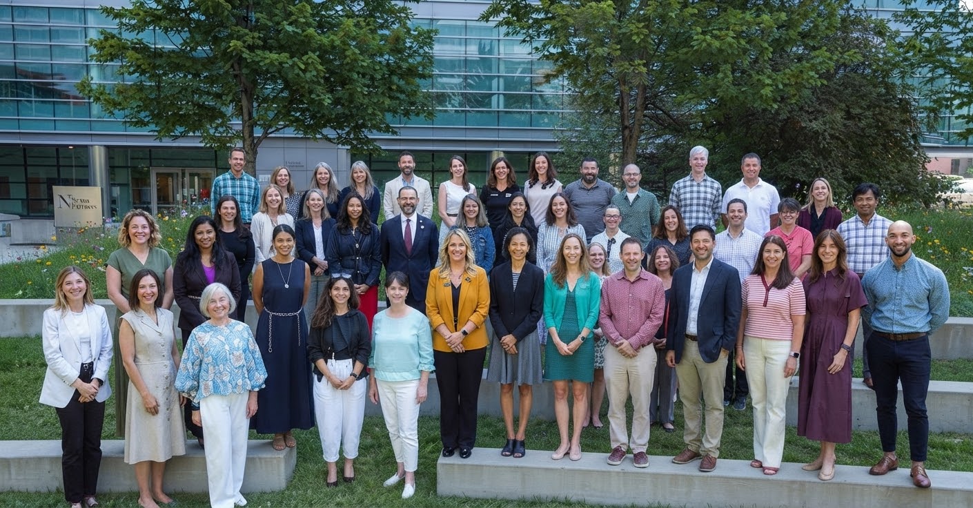Taival Leadership participants gathered outside a modern glass-paneled building